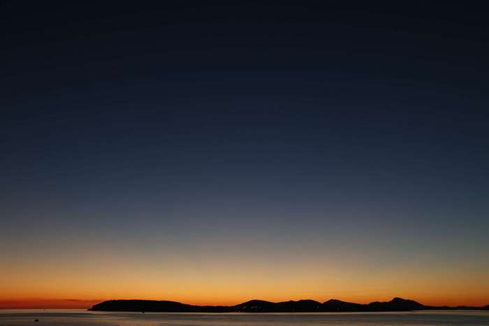 Sunset over the sea with islands silhouette