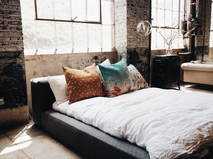 Industrial bedroom with large windows and a bed