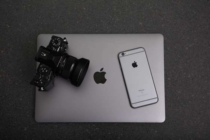 Apple laptop with iPhone and camera