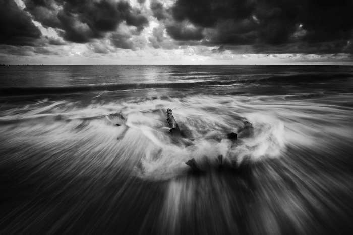 Long exposure of waves crashing on a beach at dusk
