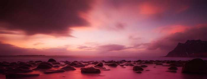 Pink sunset over rocky beach and ocean