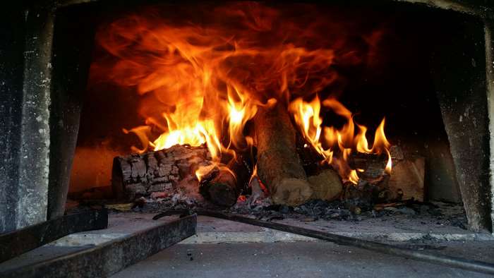 Wood fired oven with burning logs