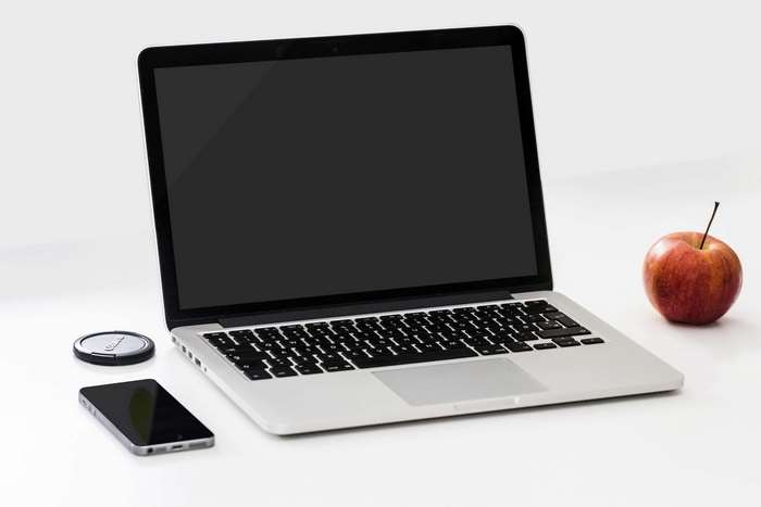 Apple, Laptop, Smartphone, and Wireless Charger on Desk