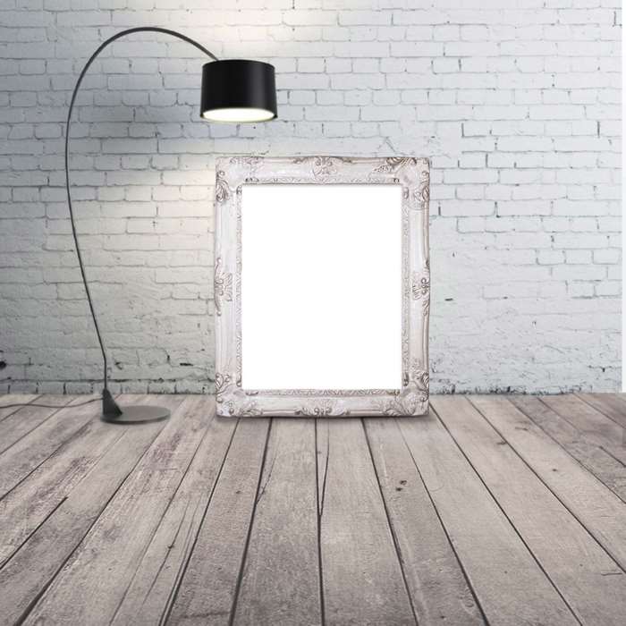 Floor lamp and ornate frame against white brick wall