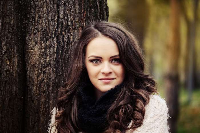 Woman leaning on a tree in autumn
