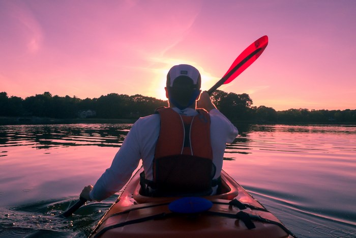 Man kayaking during sunset on a lake