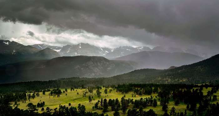 Rocky Mountains landscape with stormy clouds and forest