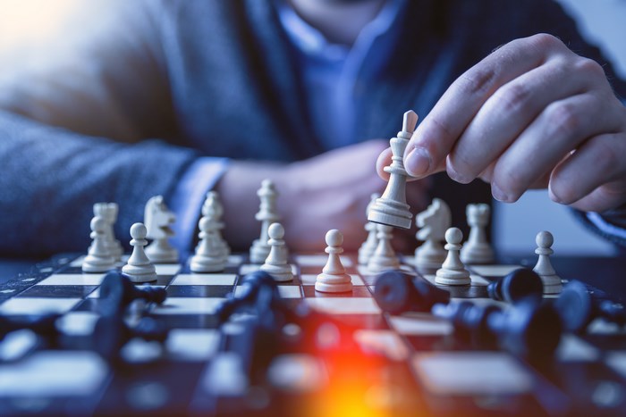 Person playing chess, moving a white king