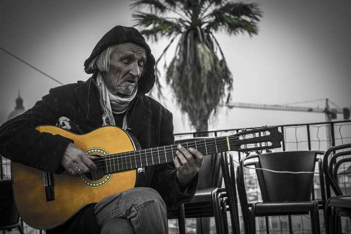 Elderly man playing acoustic guitar