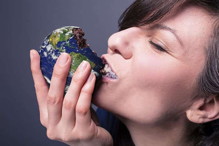 Woman eating the planet Earth cake
