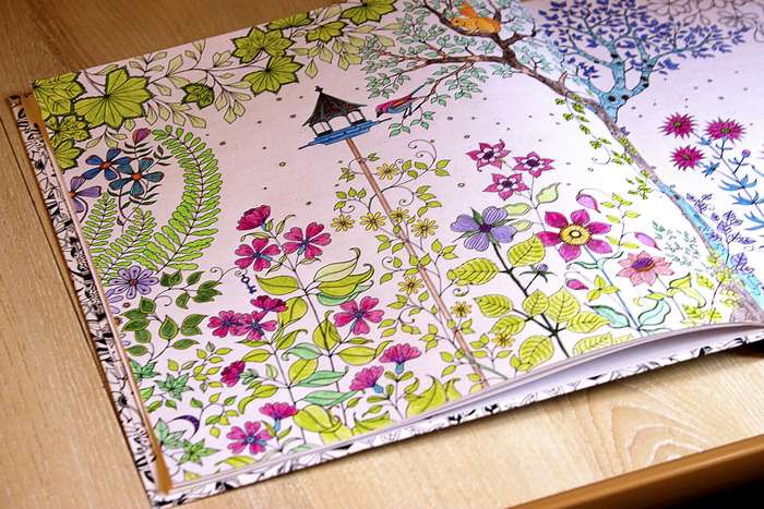 Coloring book page with flowers and a birdhouse