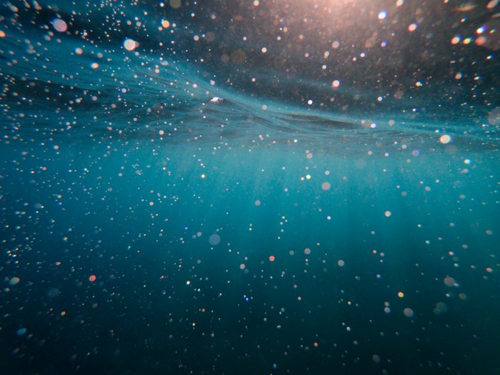 Underwater view with sun rays and bubbles