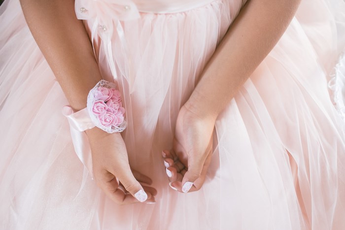 Girl in a pink dress with a floral wrist corsage