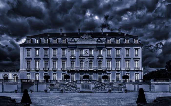 Baroque mansion facade with dark stormy clouds