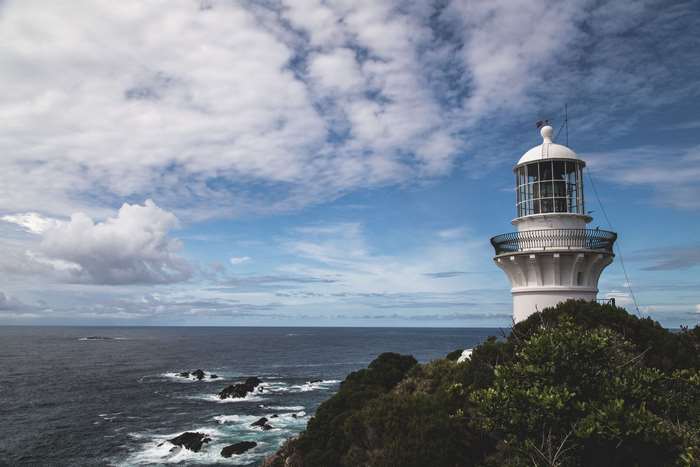 White lighthouse on a cliff overlooking the ocean