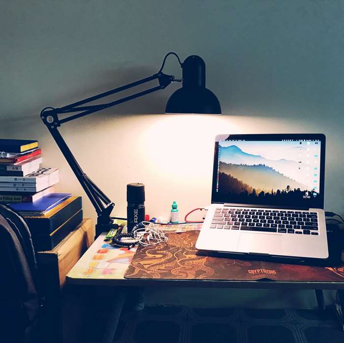 Desk with laptop, lamp, and books