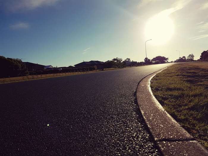 Curvy road with sunlight and houses