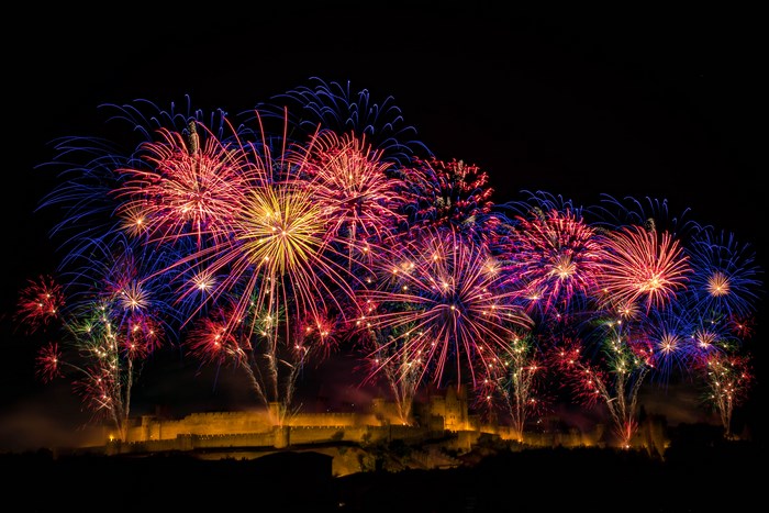 Fireworks explode over a castle at night