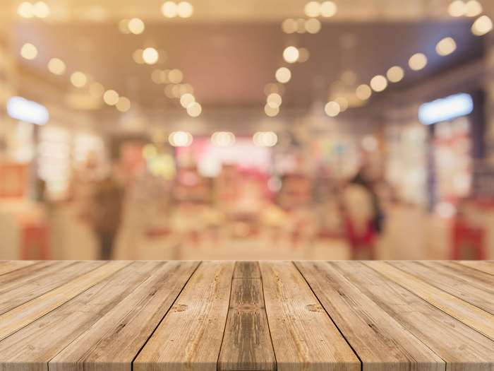 Wooden table in front of a blurred store interior with bokeh lights