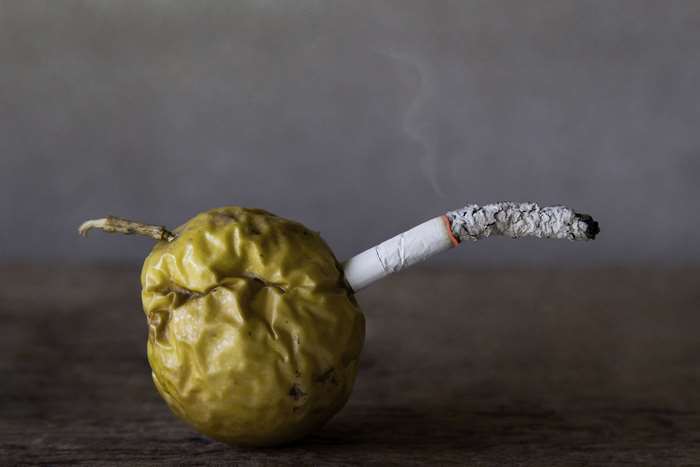 Rotten fruit with a lit cigarette