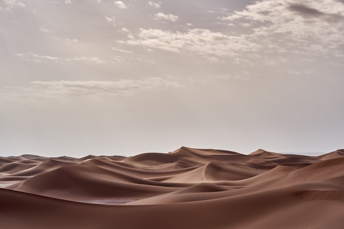 Vast Sahara Desert Sand Dunes Under Cloudy Sky