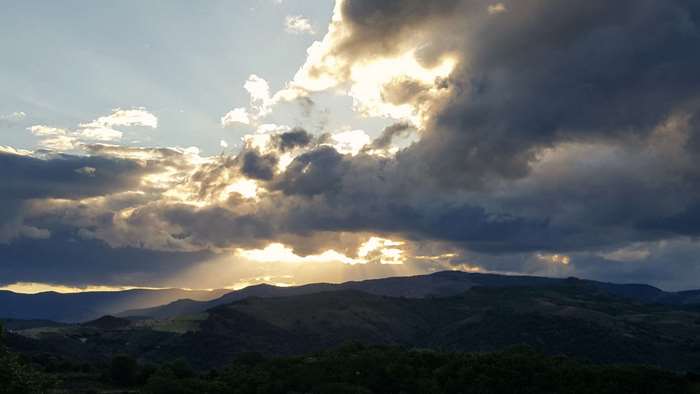 Sun rays through stormy clouds over mountains