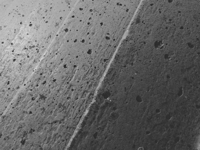 Close-up of textured grey concrete with lines and pores