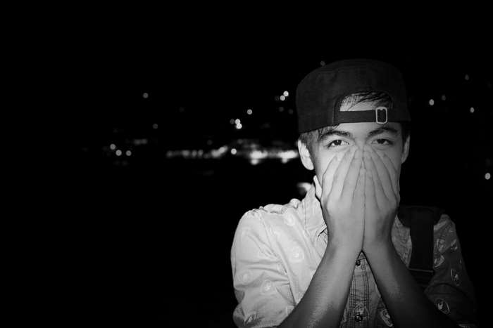 Black and white photo of a person covering their mouth