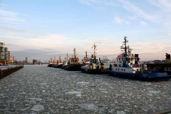 Tugboats docked in icy Hamburg harbor in winter 4K