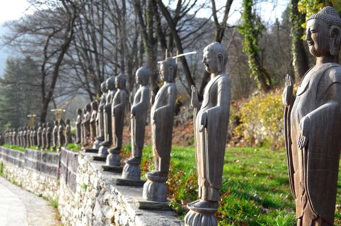 Line of Buddhist statues in a park