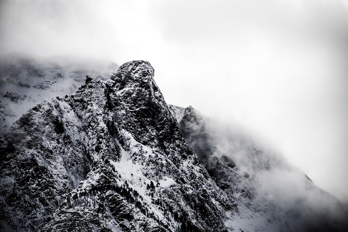 Snow-covered mountain peak shrouded in fog