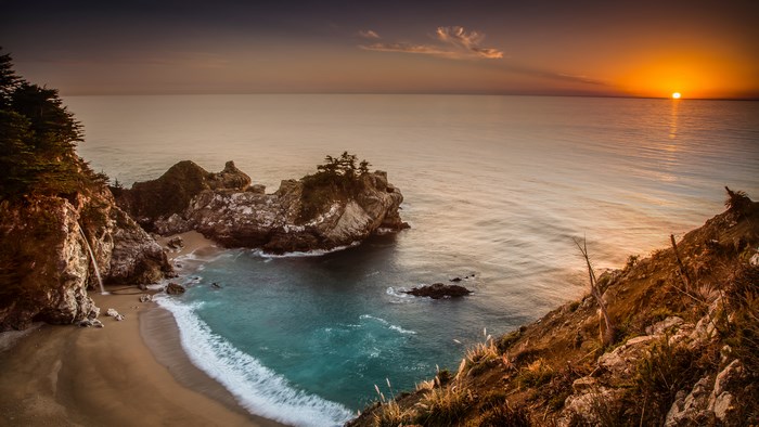 Sunset Over Rocky Beach with Waterfall