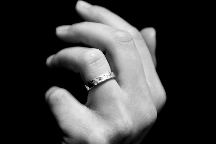 Black and white detail of a woman's hand with a ring