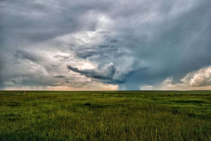 Storm clouds over a vast green field