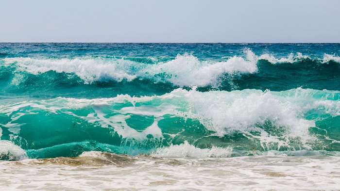 Turquoise ocean waves crashing with sea spray