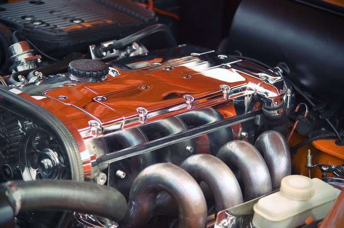 Close-up of a polished chrome and orange car engine