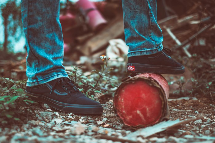 Vans shoes on a red pipe in urban junk