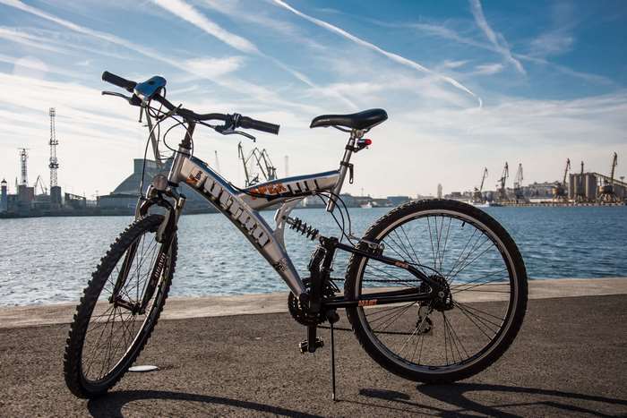 Full suspension bicycle by the sea with industrial background