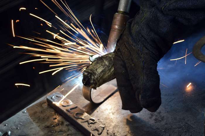 Worker welding metal with sparks flying
