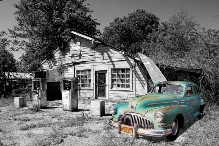 Old gas station with vintage car and surfboard
