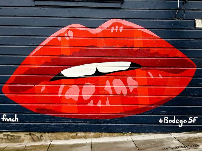 Red lips mural on a dark blue wooden wall