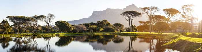 Panoramic lake reflection with trees and mountain