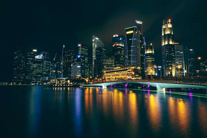Singapore skyline at night with illuminated bridge and river