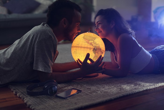 Couple holding a glowing globe on a rug
