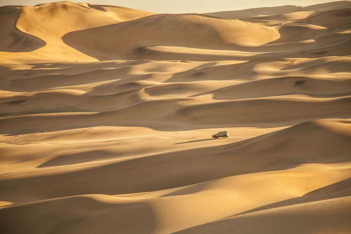 4x4 vehicle driving through Namib Desert sand dunes