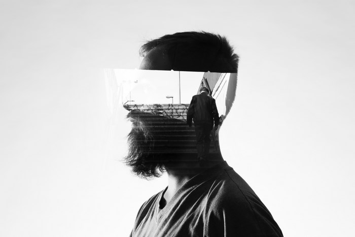 Double exposure of a man and a person walking up stairs