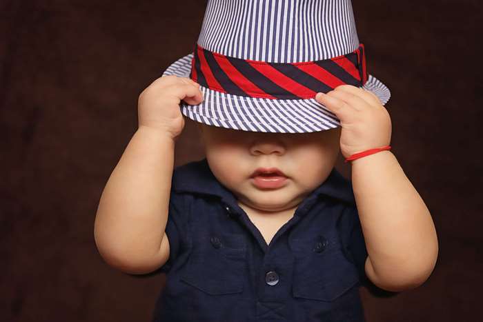 Baby boy wearing a striped fedora hat