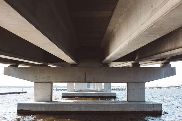 Underneath a modern concrete bridge over water