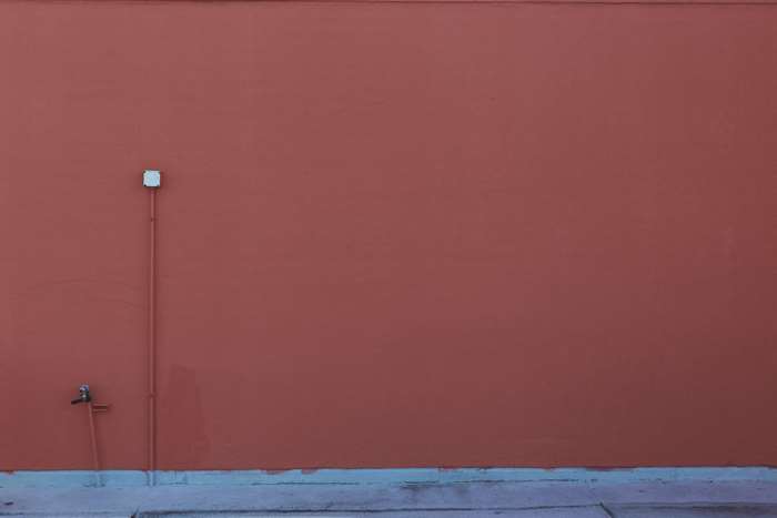 Red wall with pipes and faucet