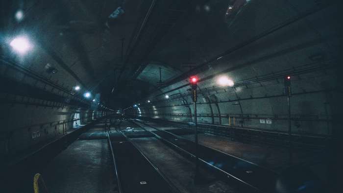 Dark train tunnel with red signal lights
